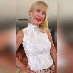 White sleeveless top. Diamond pattern. ruffle trim.